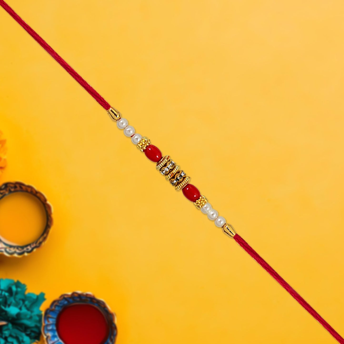 Designer Pearl Beaded Rakhi highlighting intricate red beads and golden shimmering details.
