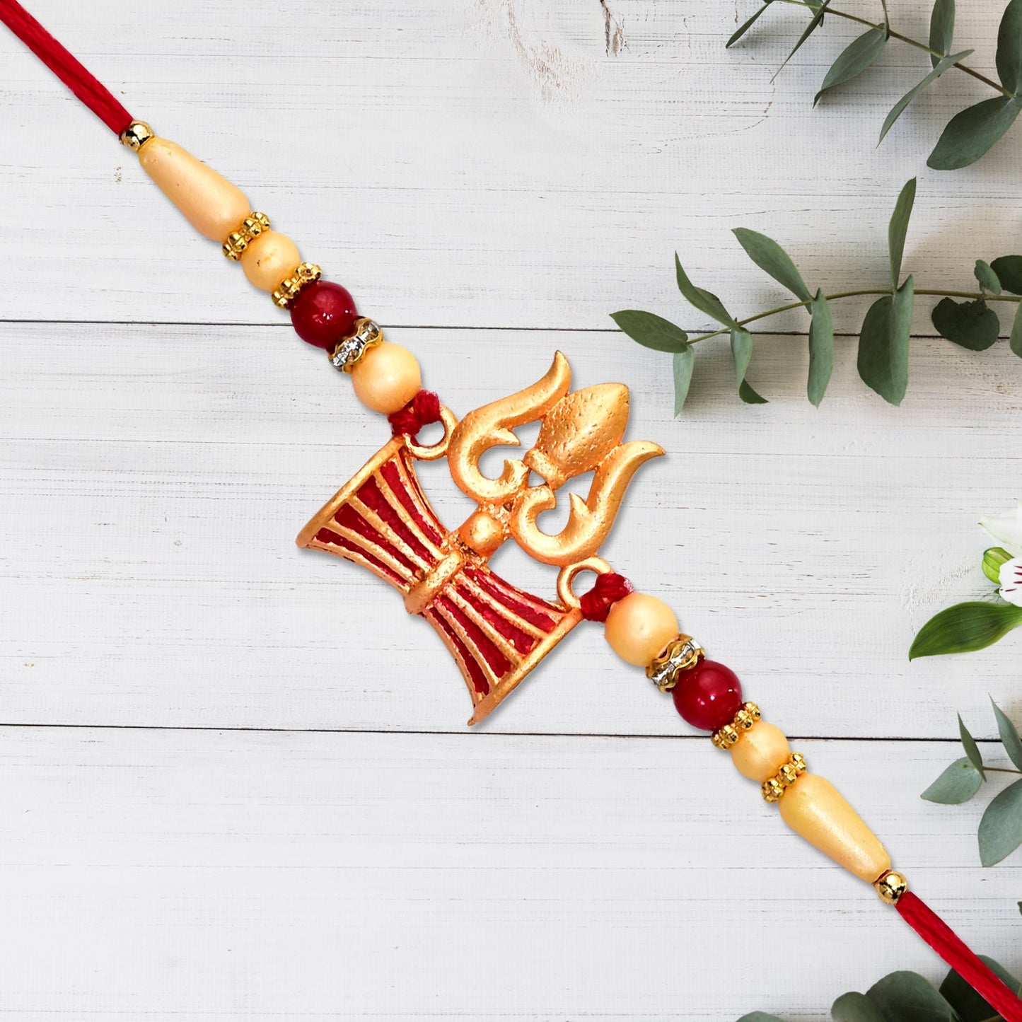 Elegant Shiva Trishul Rakhi showcasing intricate Damru design on a light background.