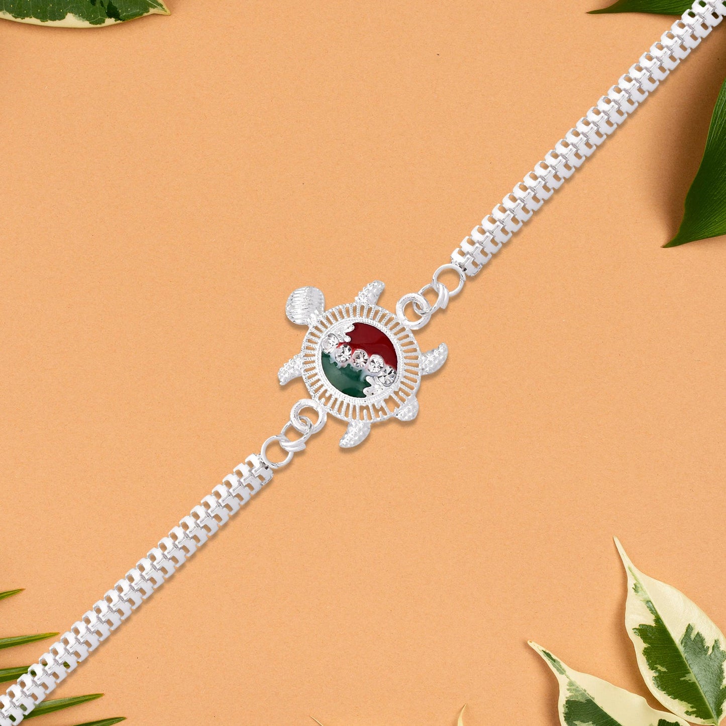 Stylish silver chain Turtle Rakhi laid on festive background for brother's Raksha Bandhan celebration.