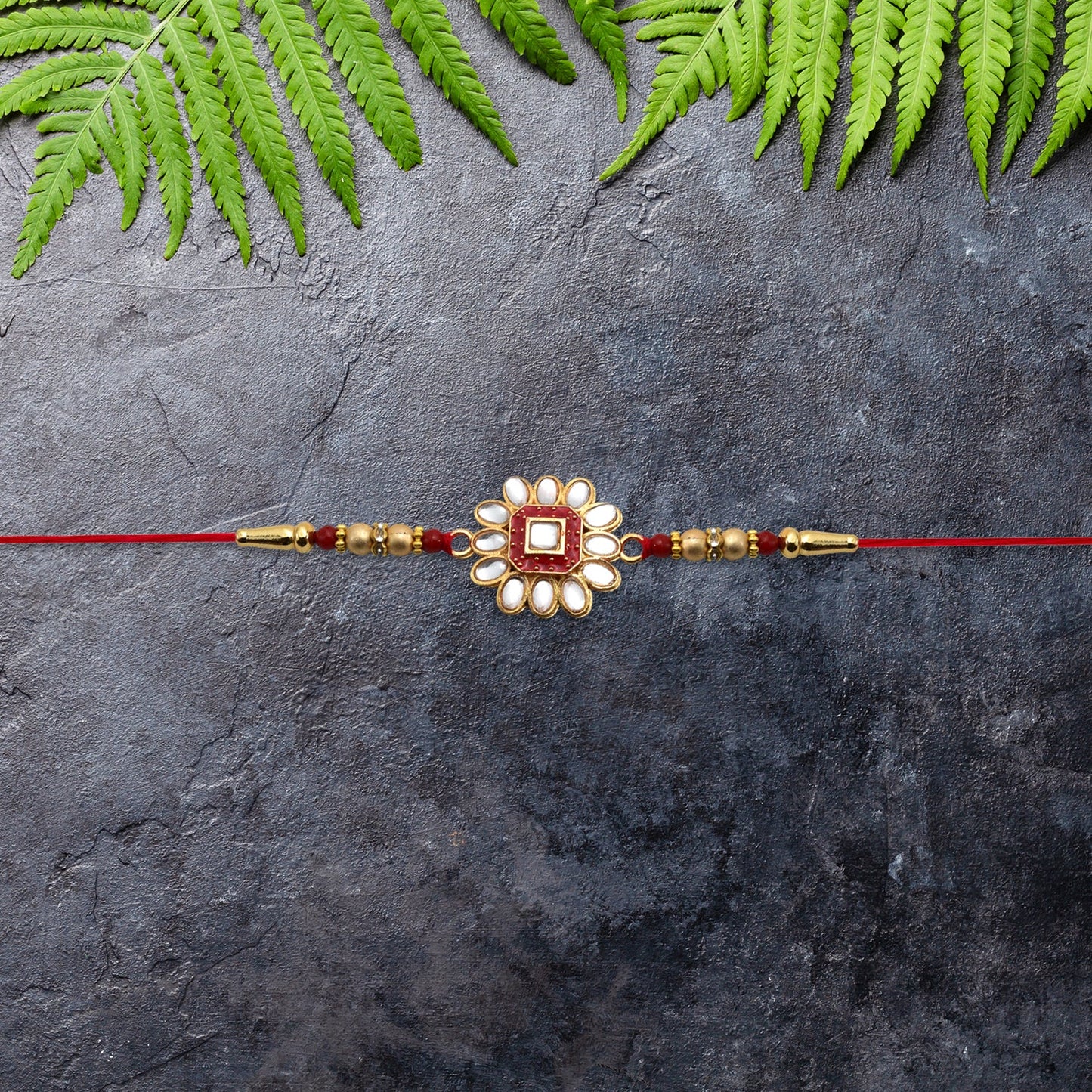 Flower design Traditional Rakhi adorned with stones and beads tied on brother's wrist.