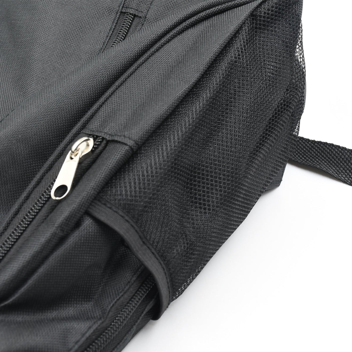 A close-up of the side of a black fabric backpack, showing a silver zipper pull on a pocket and a mesh side pocket.