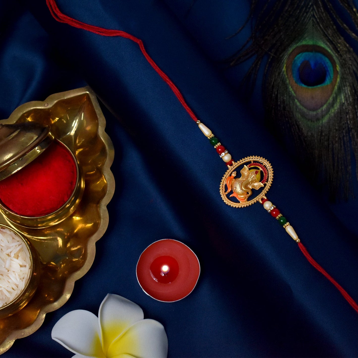 Detailed shot of the divine Ganesha idol and intricate thread work on rakhi.