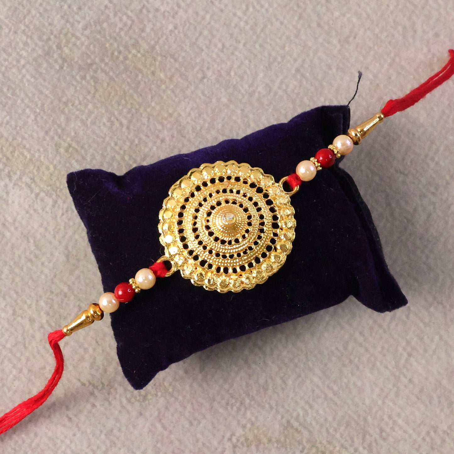 Elegant Rakhi featuring gold centerpiece and pearl beads