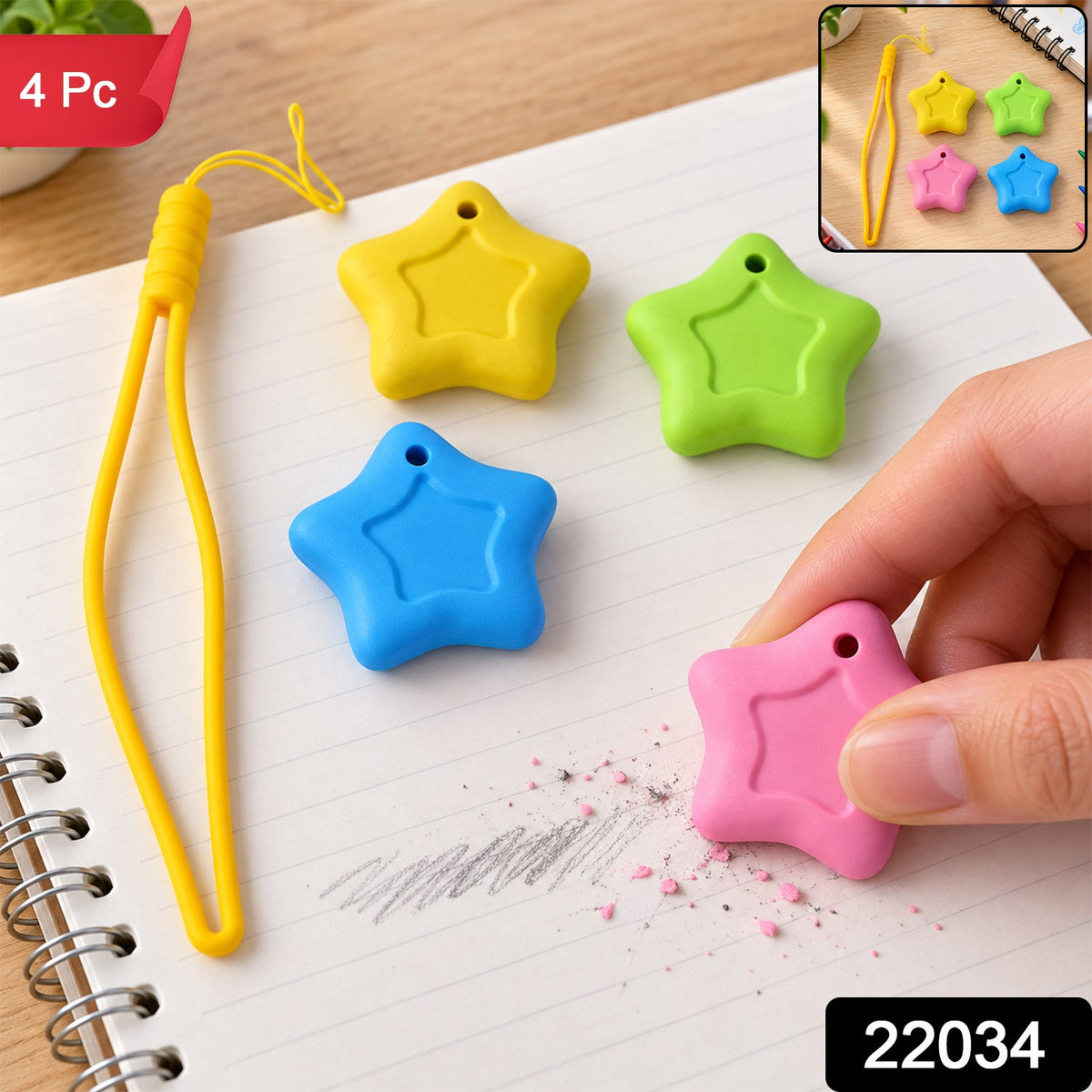 A hand holds a pink star eraser, removing pencil marks from a notebook page, with yellow, green, and blue star – view 2