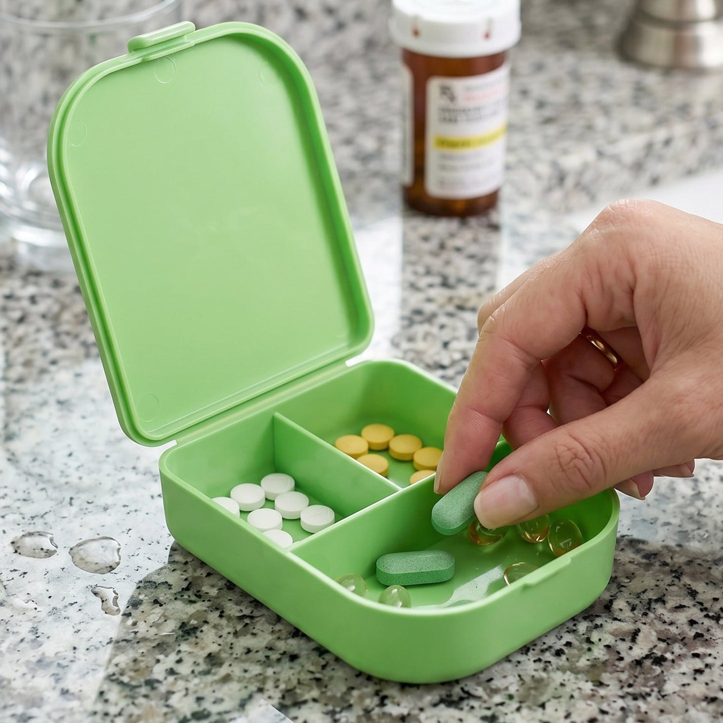 Hand holding a portable pill organizer box, ready for travel.