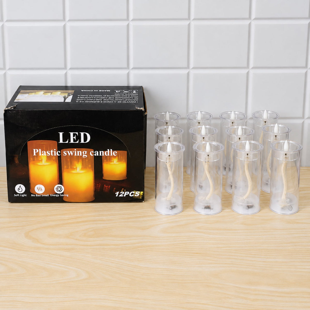 A product box for LED swing candles sits on a light wooden surface, next to twelve clear plastic tubes without their flames
