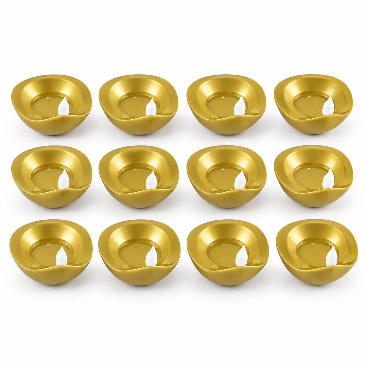 Twelve unlit golden diyas with white plastic wicks are neatly arranged in four rows on a white surface.