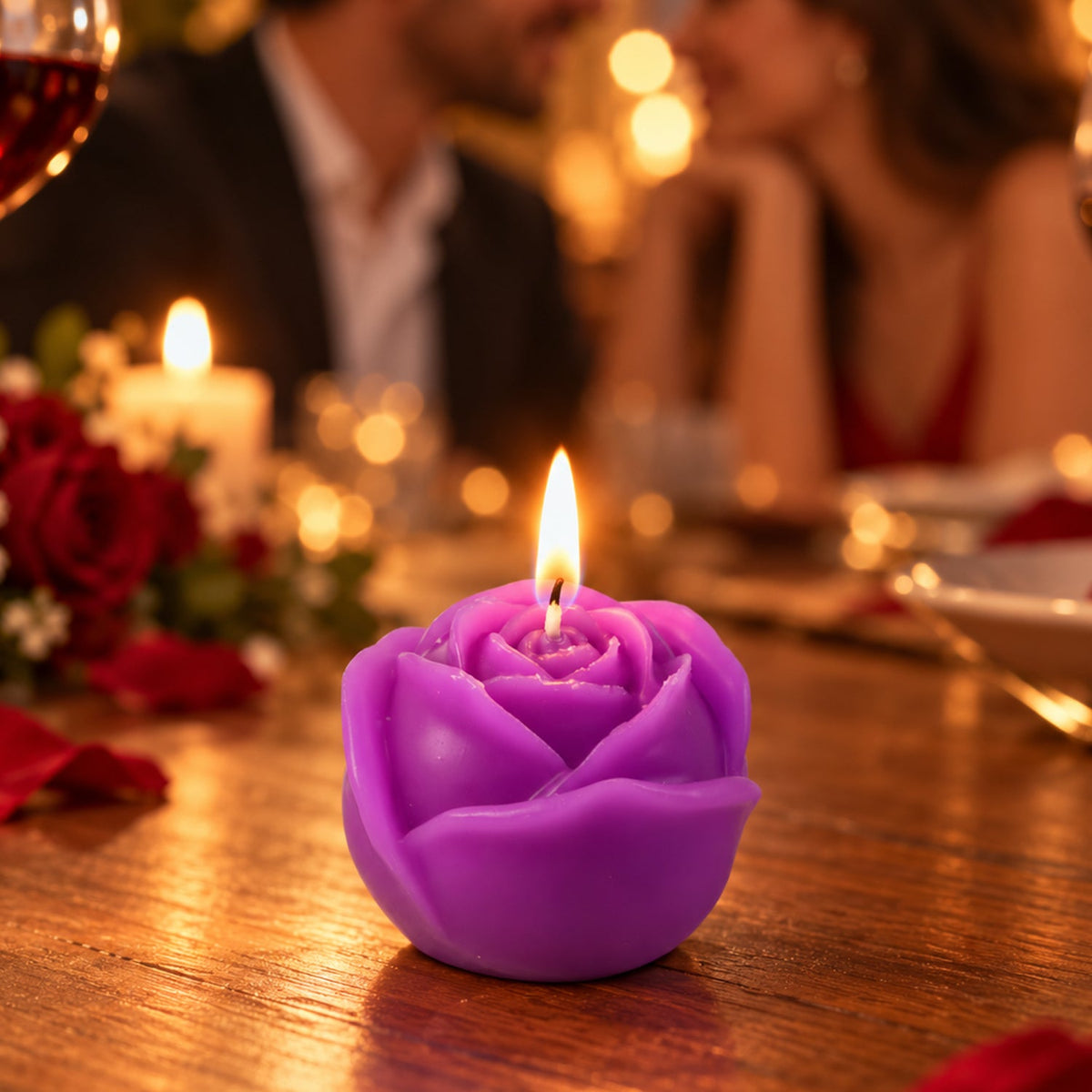 A lit purple rose-shaped candle sits on a wooden table during a romantic dinner setting with blurred figures in background.