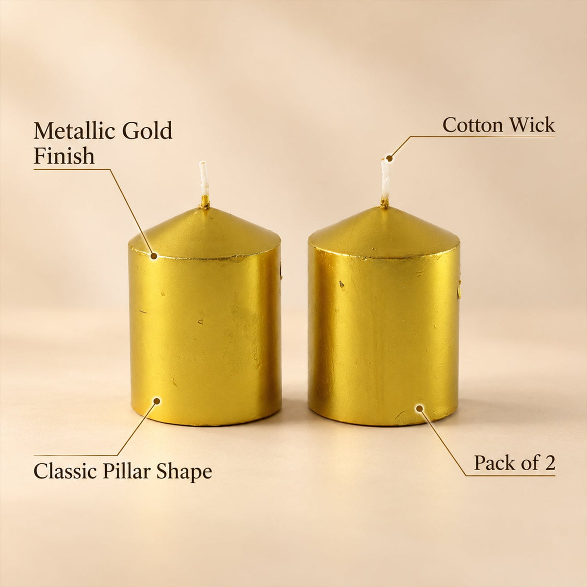 Two unlit golden metallic pillar candles with labels pointing to their metallic finish, cotton wick, and classic pillar