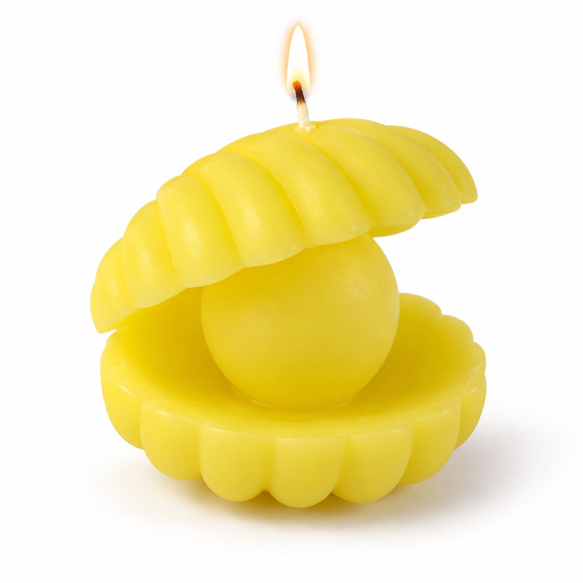 A yellow shell-shaped candle with a spherical pearl center is lit and stands alone on a clean white background.