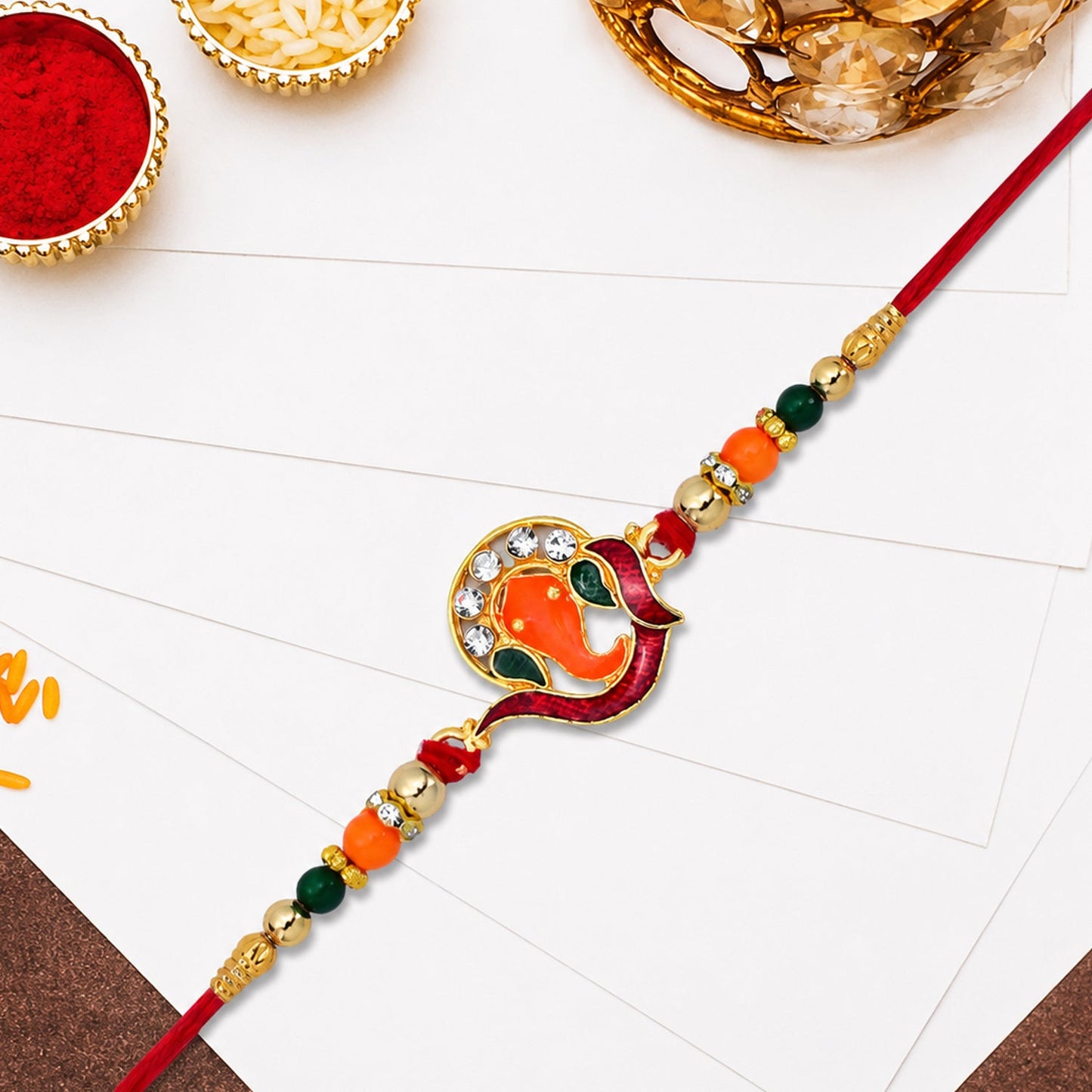 Close-up of golden Ganesha Rakhi showing beadwork and stone accents for Rakshabandhan