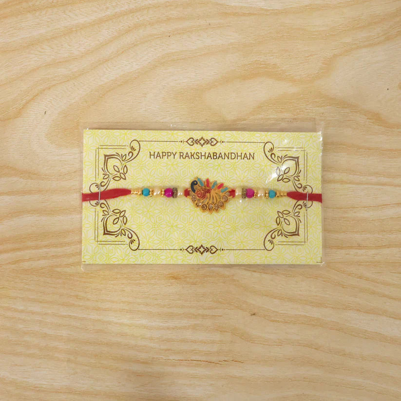 Back view of Peacock Rakhi showing traditional red thread making it comfortable