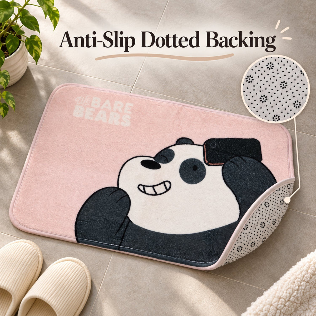A pink panda mat with a corner lifted to reveal a dotted anti-slip backing, next to slippers on a tiled floor.