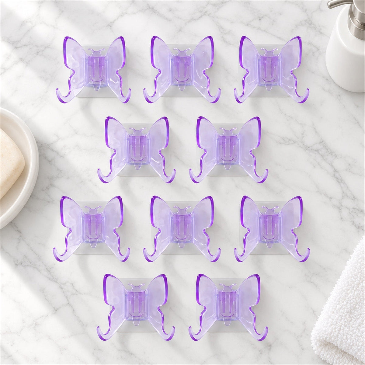 Ten self adhesive butterfly wall hooks arranged neatly on a surface