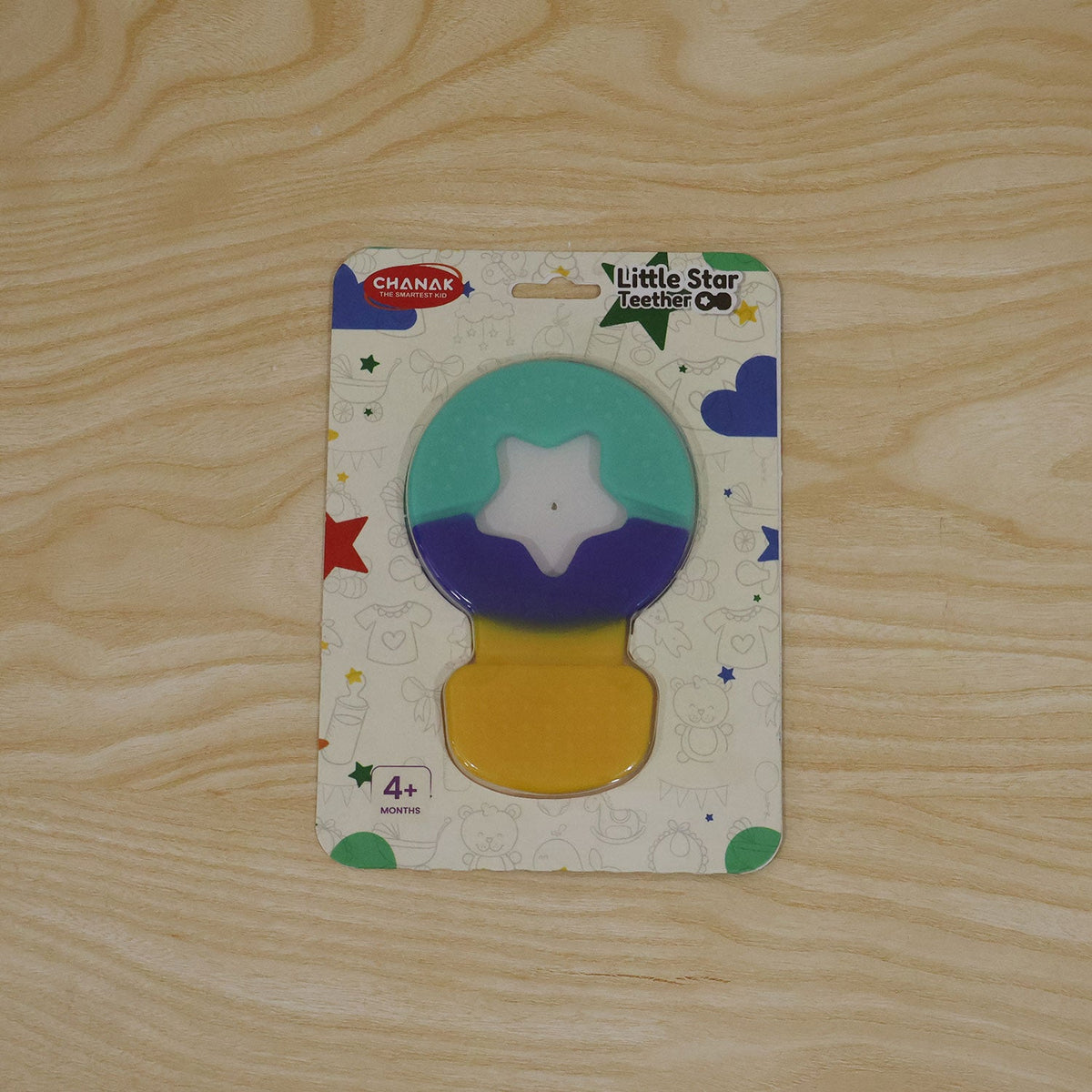 The colorful star teether is sealed in its retail packaging, featuring a