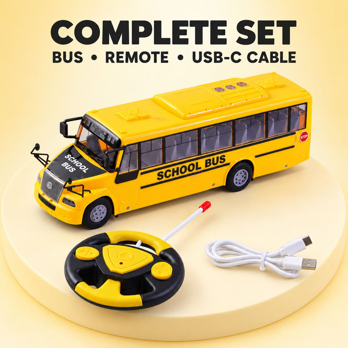 A yellow school bus toy, a black and yellow remote control, and a white USB-C charging cable on a light yellow surface.
