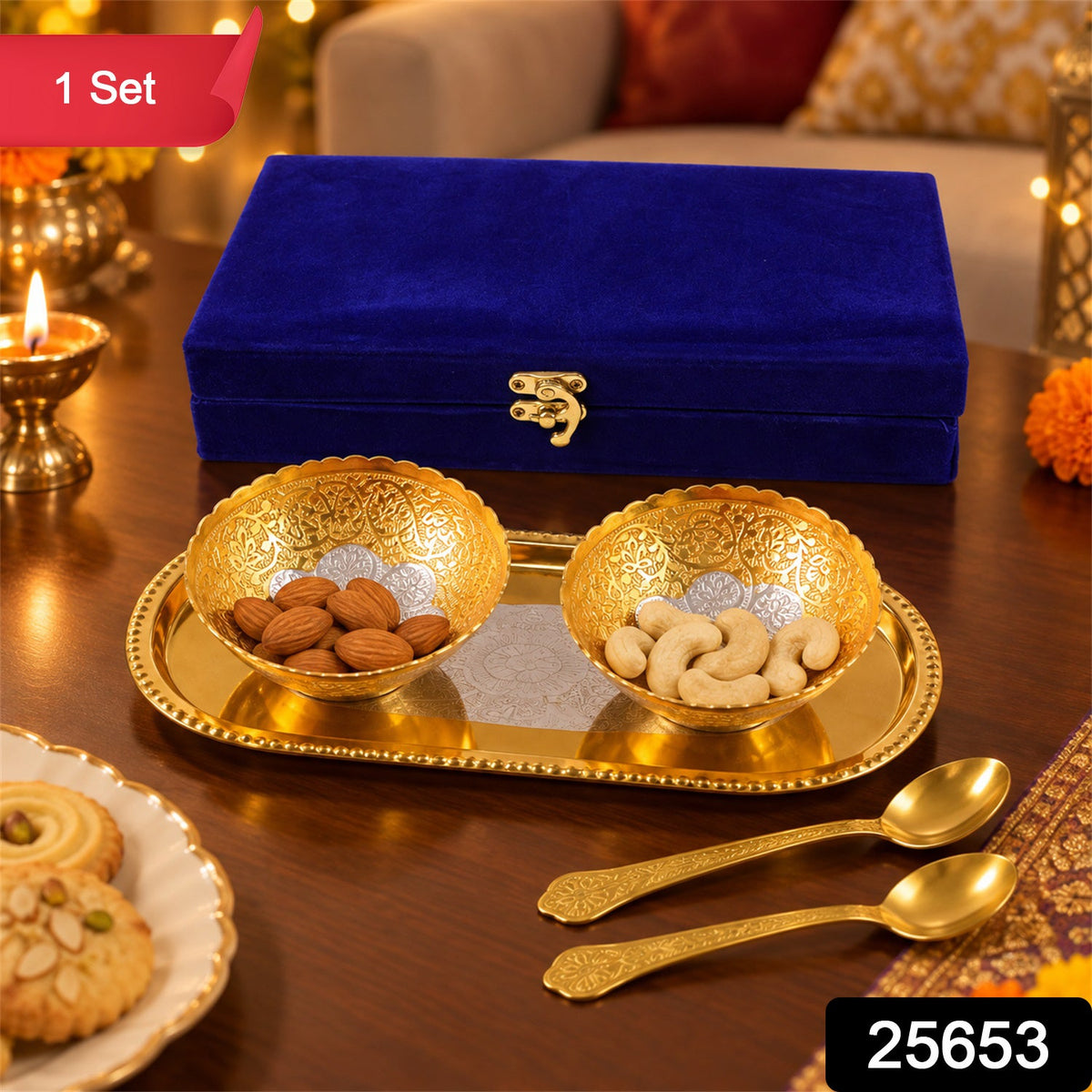 A blue velvet box, two golden bowls with nuts, a golden tray, and two small spoons on a wooden table.