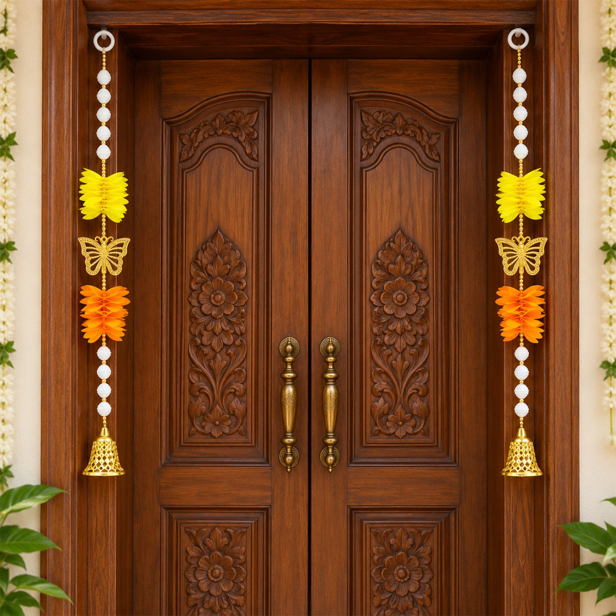 Two ornate door hangings with yellow and orange floral accents, golden butterflies, and white beads, adorning a carved