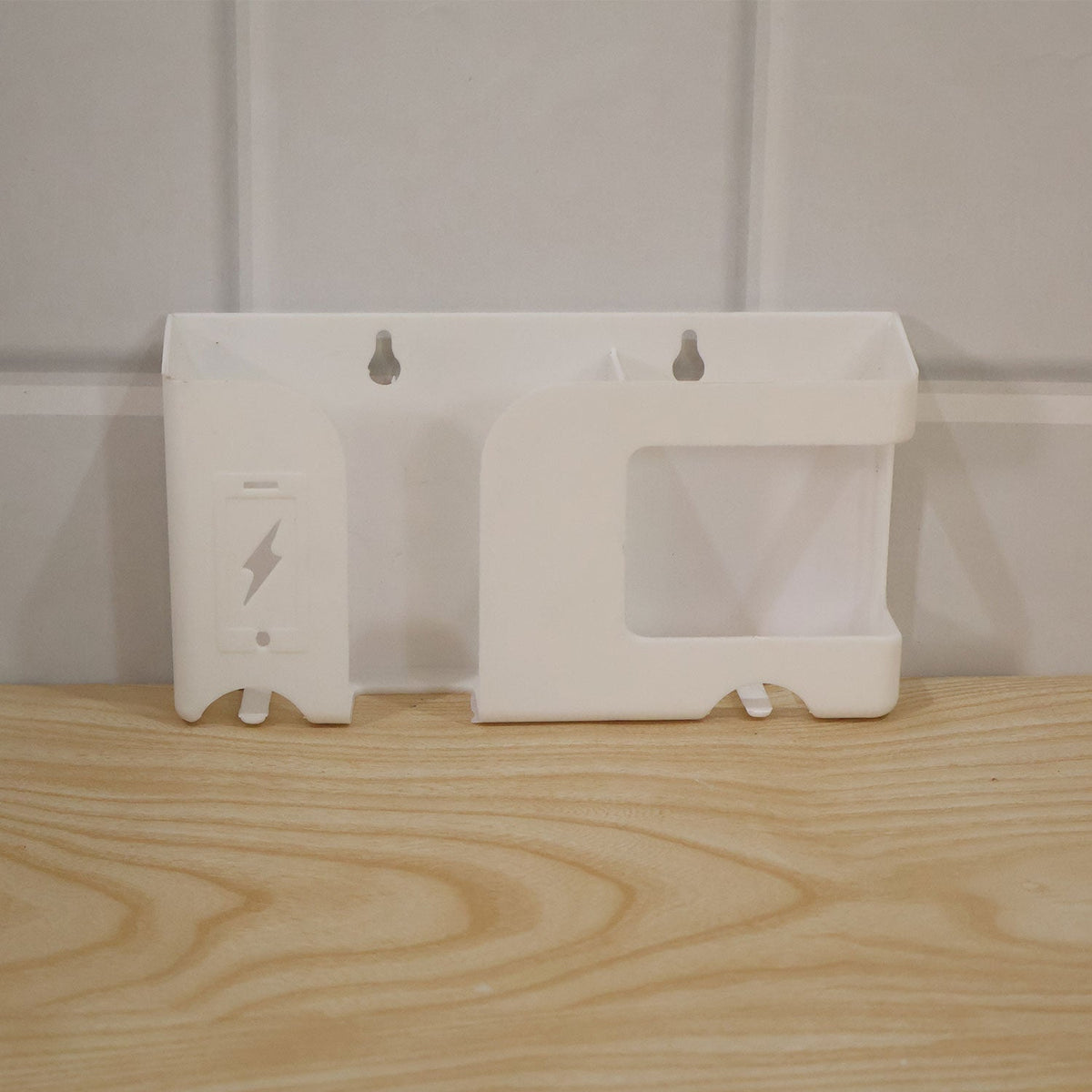 White wall-mounted organizer resting on a light wooden surface against a white paneled wall.