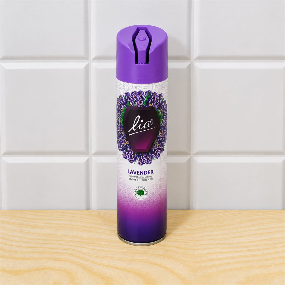 A purple and white lavender room freshener spray can stands on a light wooden surface against white tiles.