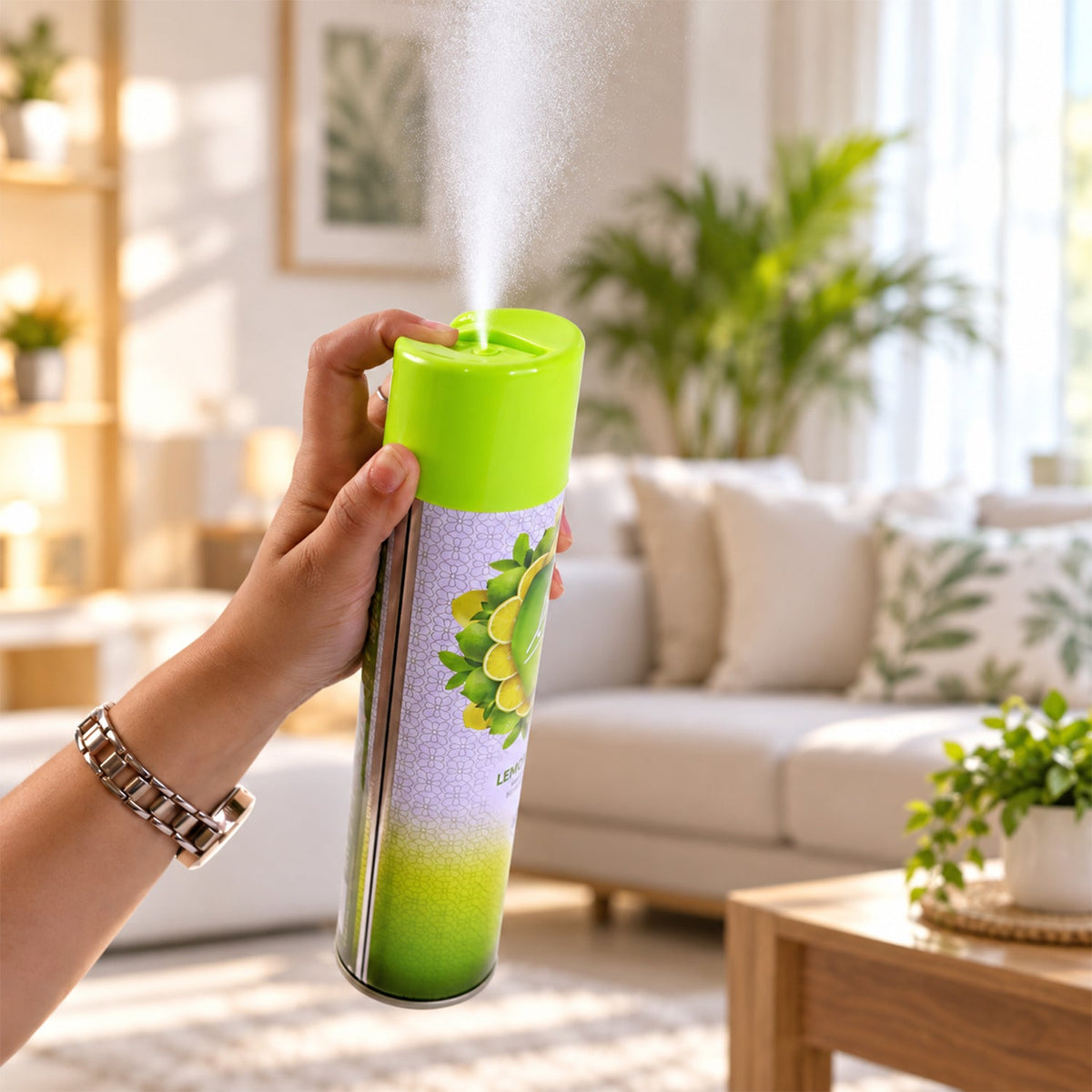 A hand holds the Lia Lemon Burst room freshener, spraying a fine mist into a bright, modern living room environment.