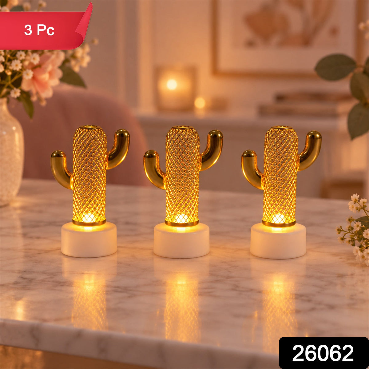 Three decorative gold cactus lights with white bases glow on a table, with a