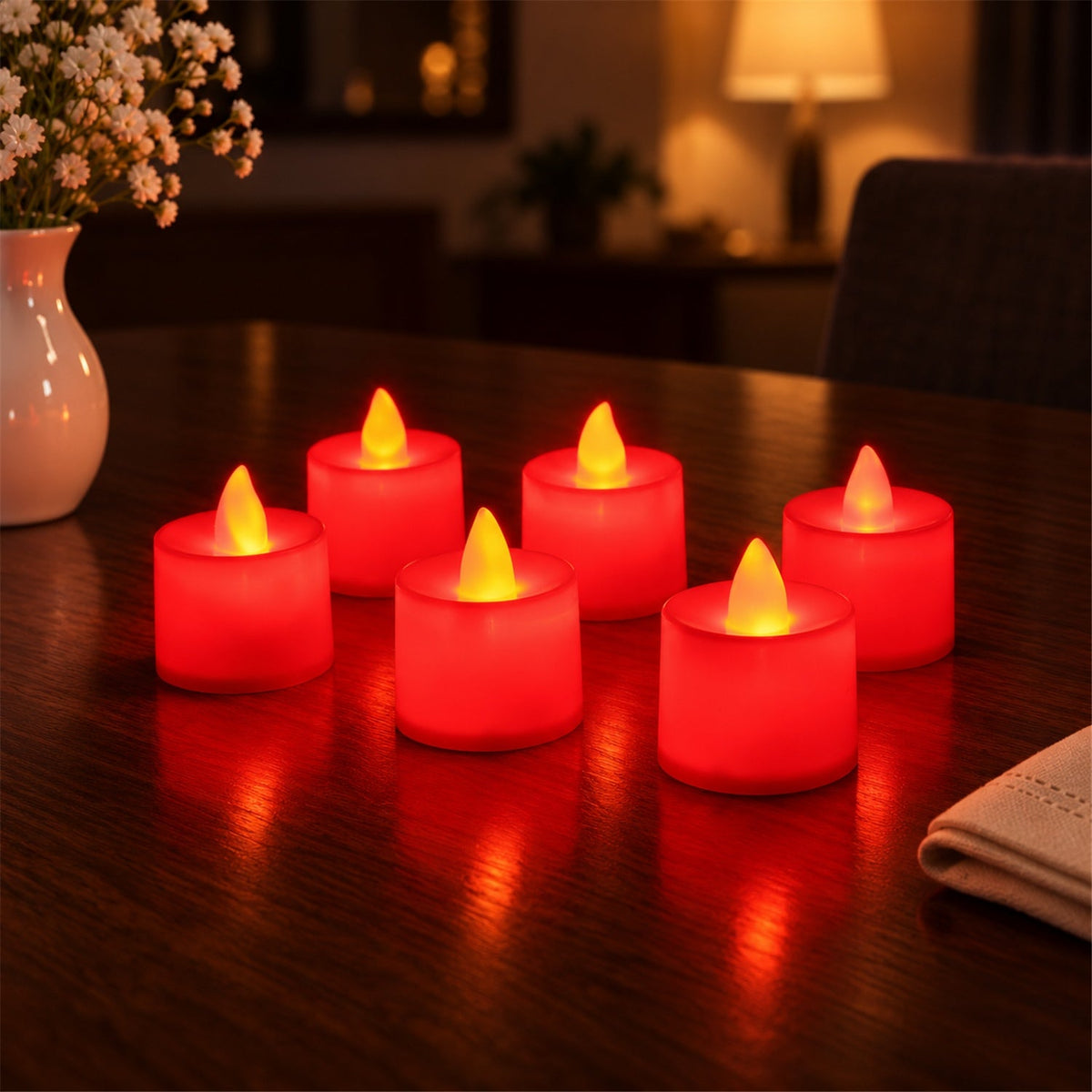 Six red flameless LED tealight candles glowing brightly on a dark wooden table next to a white vase with flowers.