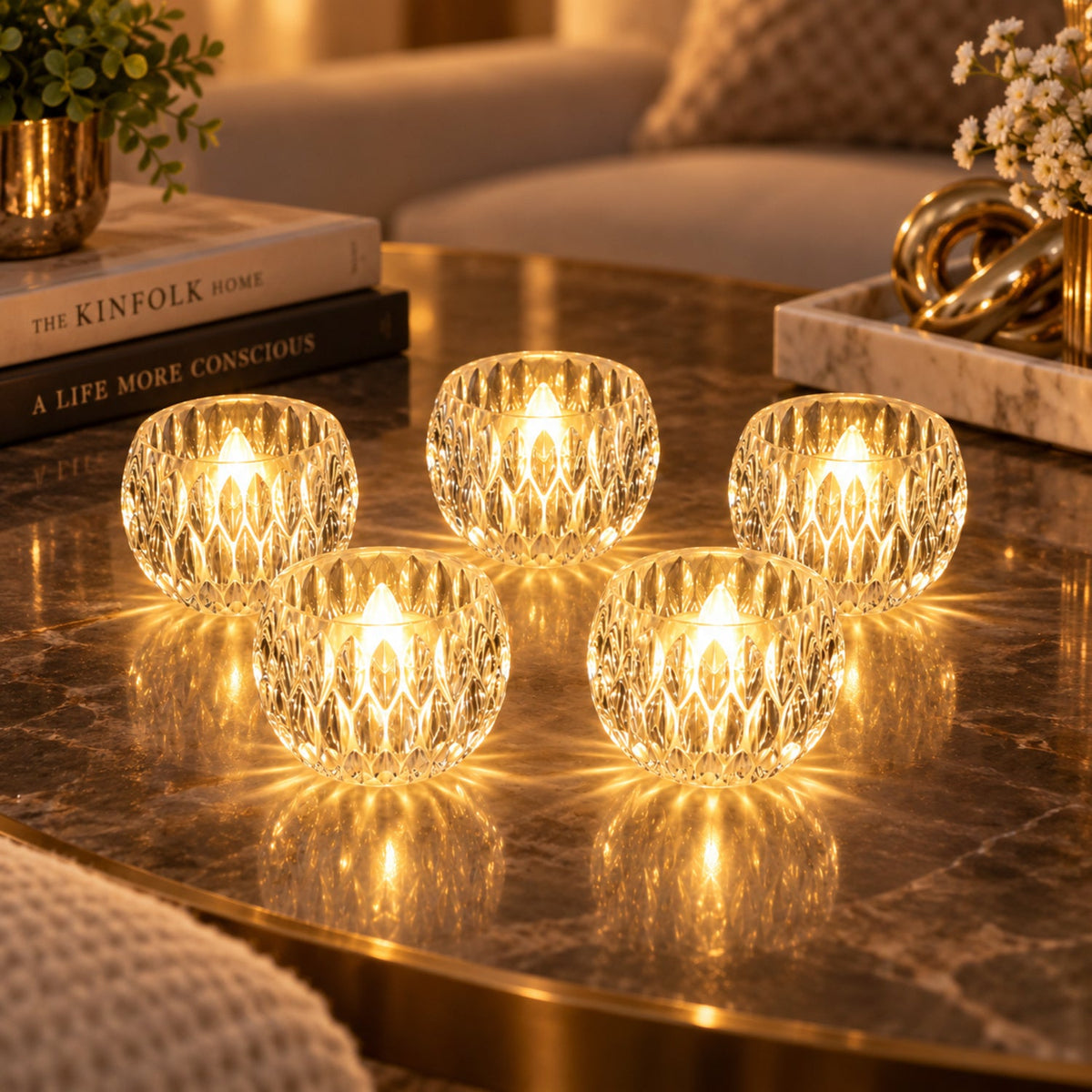 Five crystal LED tealights illuminate a dark reflective table with books and a decorative vase.