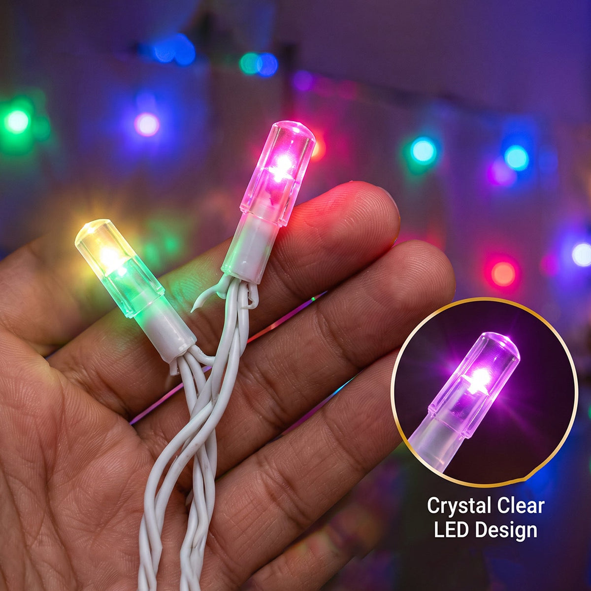 A hand holding two crystal-clear LED lights, one yellow-green and one pink, against a blurred background.
