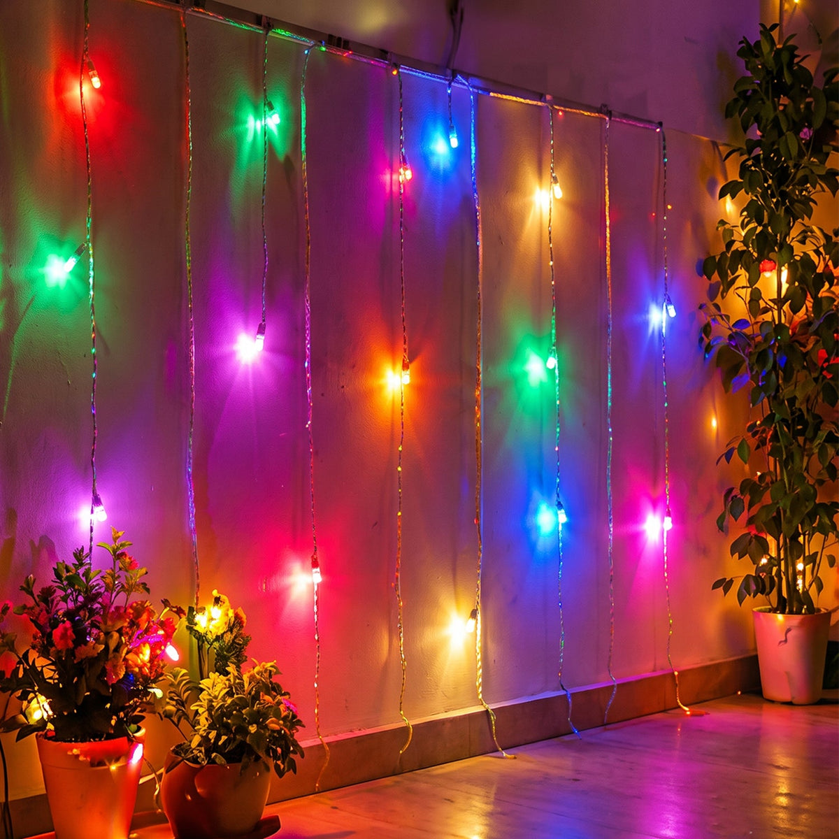 Multi-color LED curtain lights hanging vertically on a wall, illuminating potted plants below.