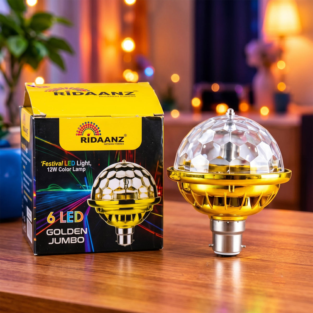 A gold and clear disco bulb with a B22 base sits next to its yellow and black packaging on a wooden table.