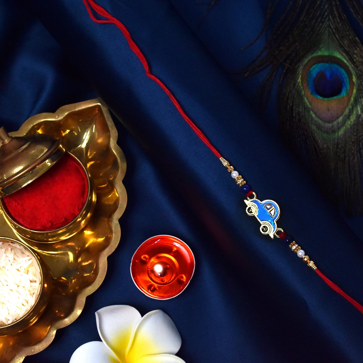 Soft skin-friendly thread and blue car motif close-up on the handcrafted kids rakhi.