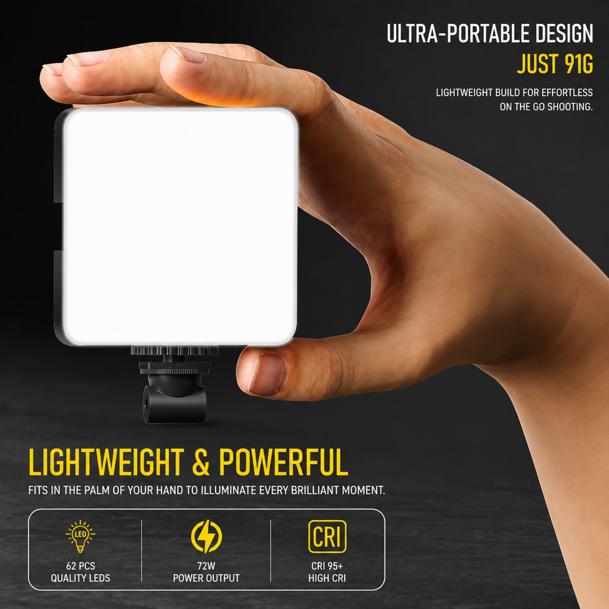 A hand holding a small, illuminated square LED video light with a white diffuser, against a dark background.