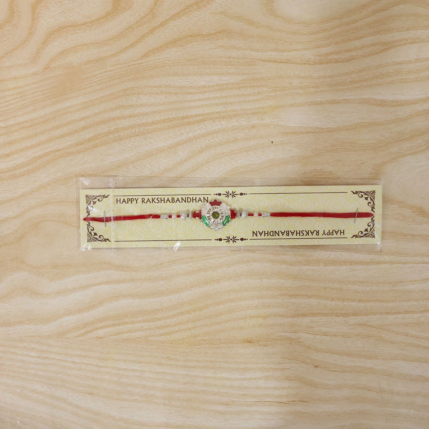 Green white flower rakhi tied on wrist with red thread