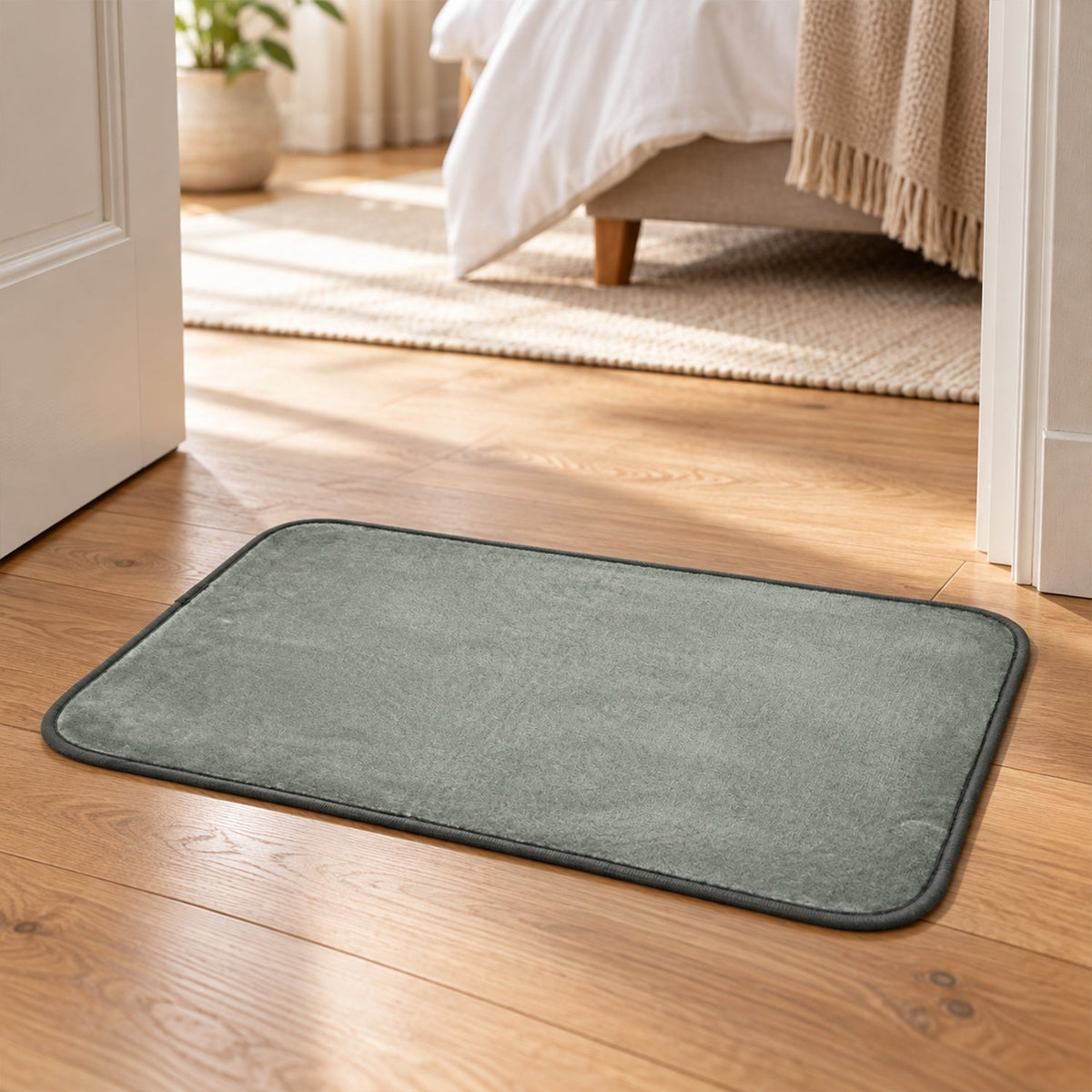 A grey rectangular mat on a wooden floor, visible through an open doorway.