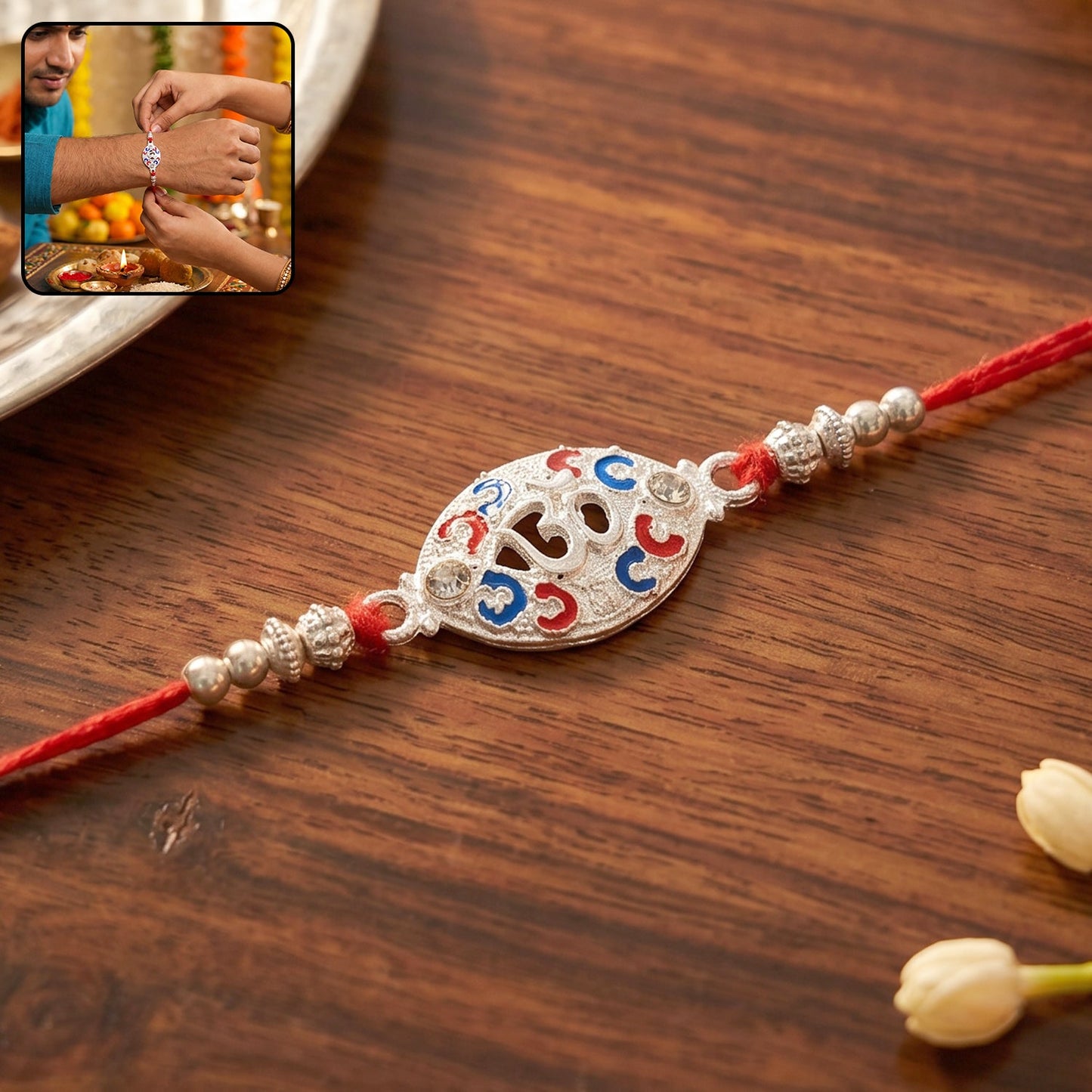 Silver Om rakhi with red thread and colorful accents, perfect for Raksha Bandhan
