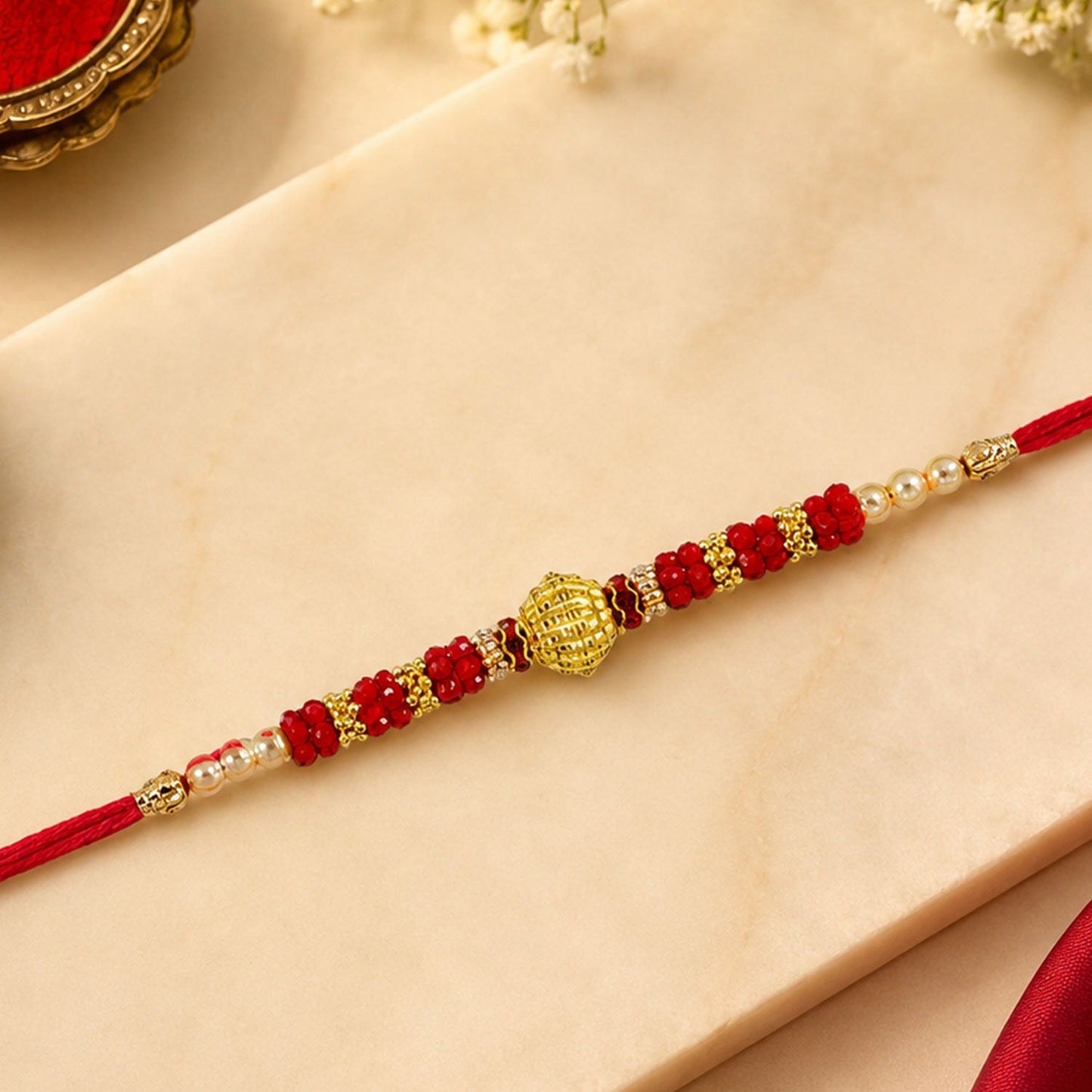 Red Bead Rakhi featuring golden centerpiece and pearl accents for brothers