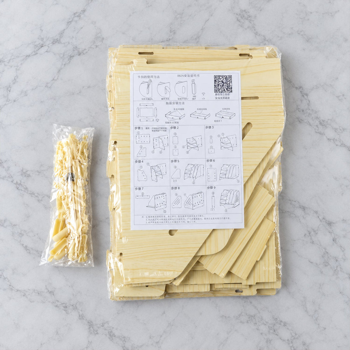 Disassembled wooden desk organizer pieces in clear packaging with assembly instructions.