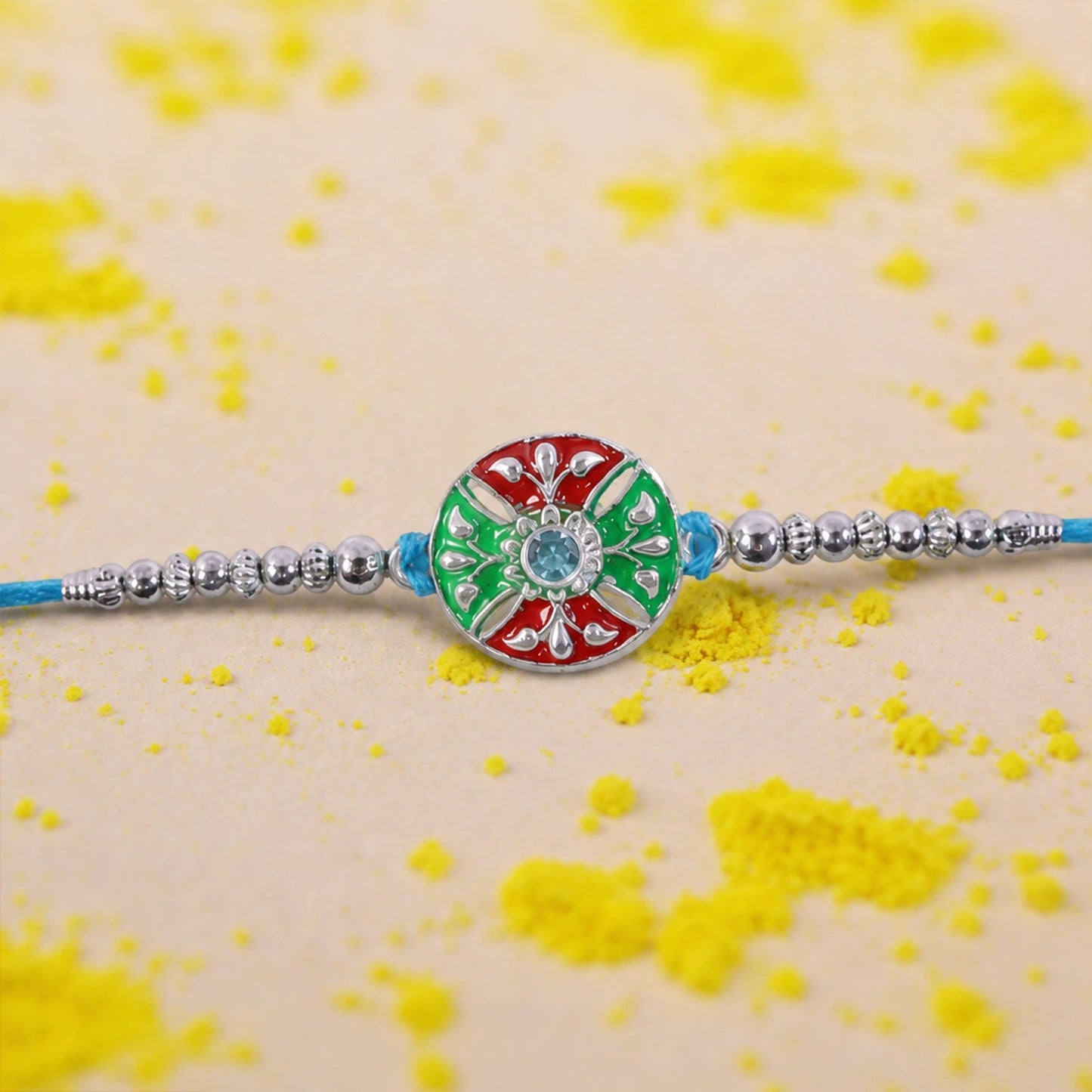 Close-up of blue thread rakhi with multicolor center and decorative beads