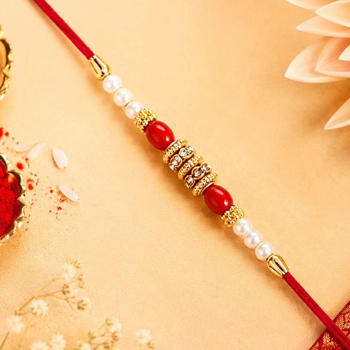 Pearl Beaded Rakhi with red beads and golden accents for Raksha Bandhan celebration.