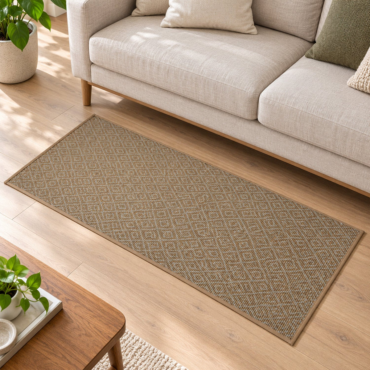 A long brown diamond pattern runner mat extends across a wooden floor in a living room with a beige sofa.