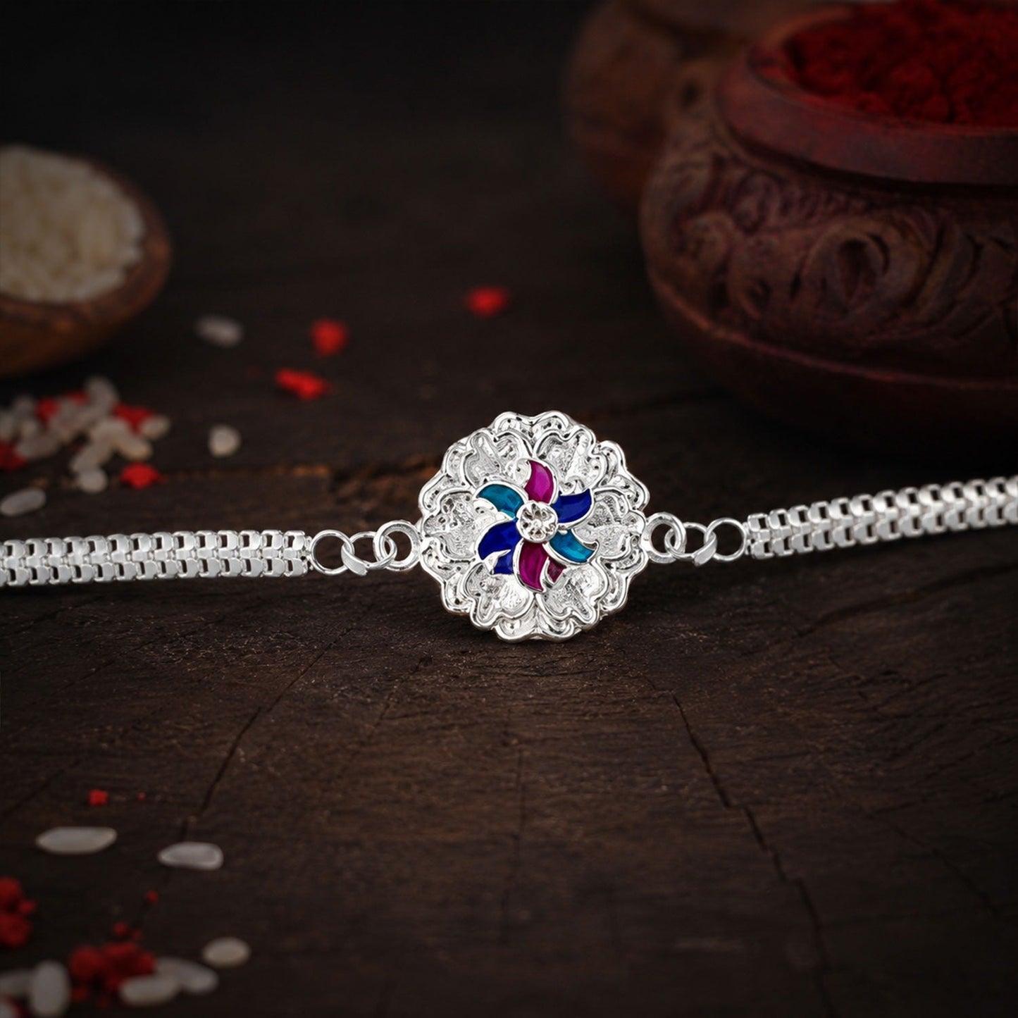 Elegant silver floral Rakhi with delicate enamel detailing and a dual chain design.