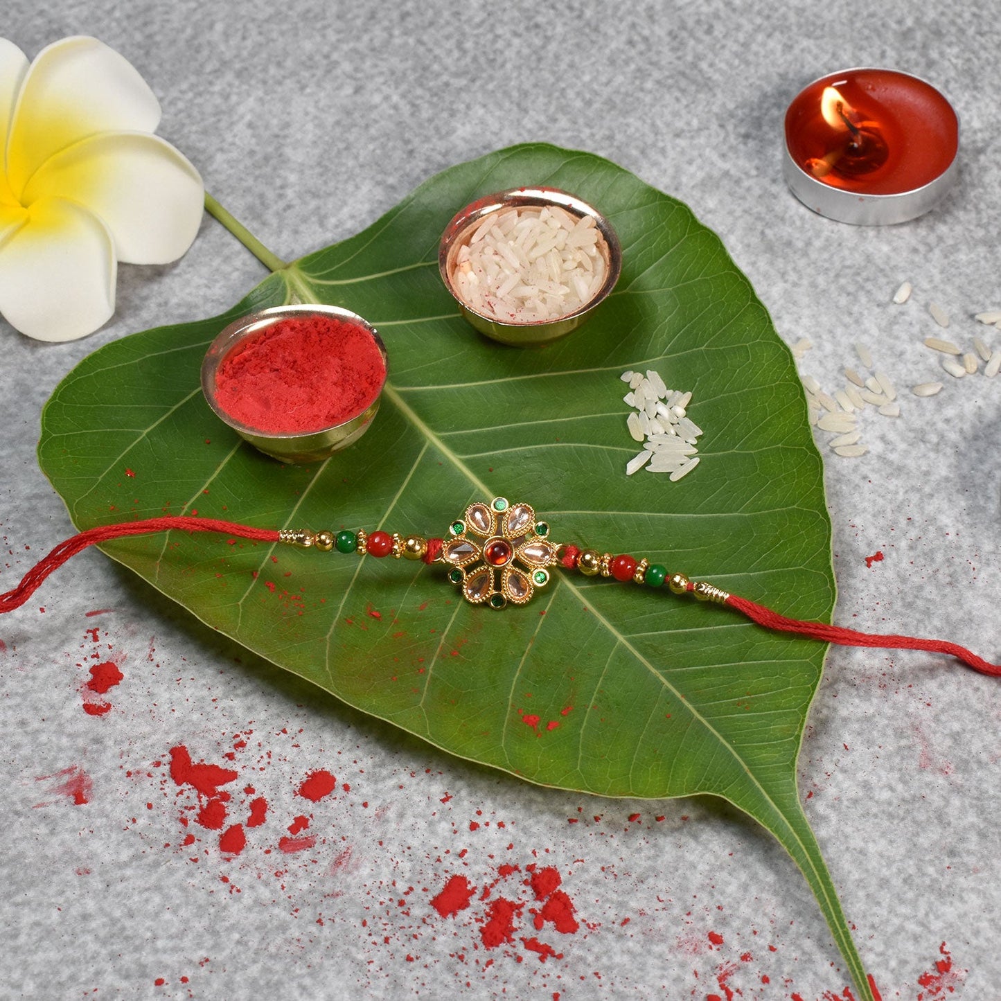 Vibrant floral Kundan Rakhi adorned with red and green beads, perfect for Raksha Bandhan.