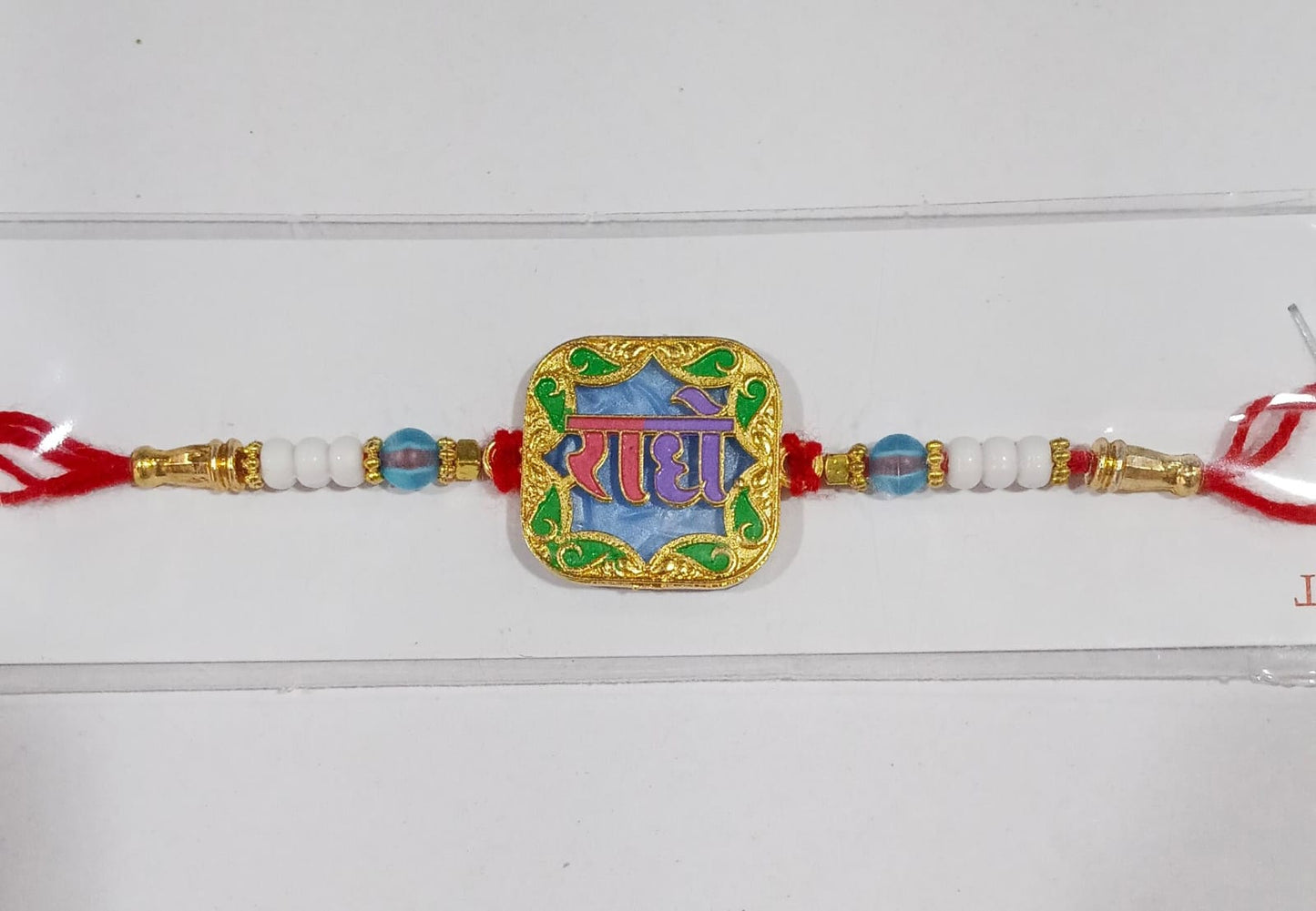Festive Radhe engraved Rakhi with colorful decorations