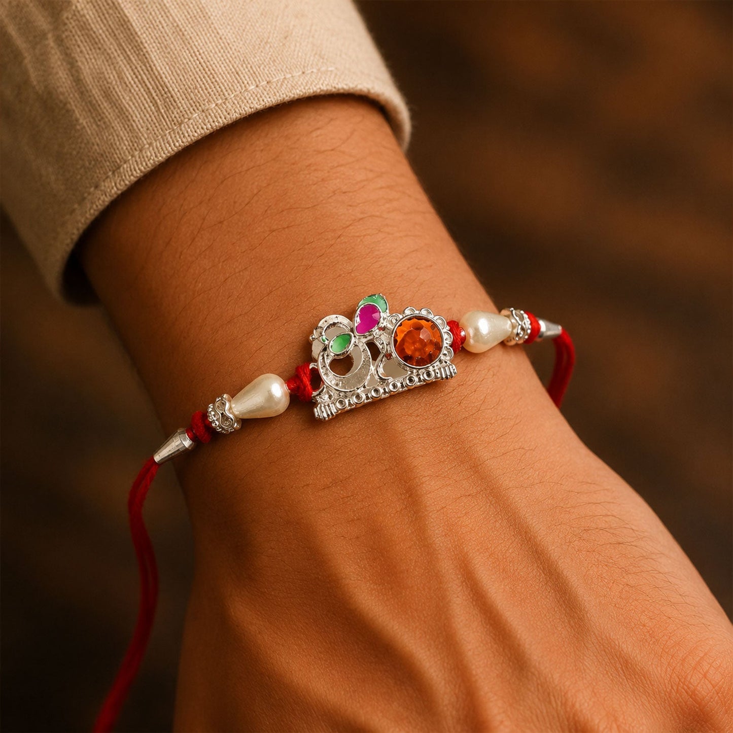 Red Gold Floral Om Rakhi displayed on wrist for celebration