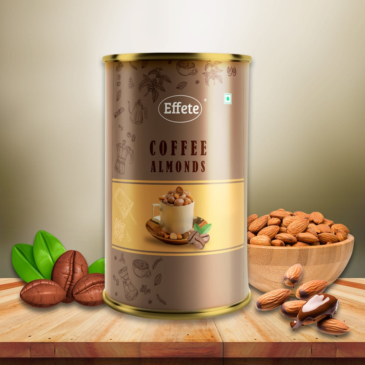 Brown and gold tin of coffee almonds with coffee beans, green leaves, and a wooden bowl of almonds on a table.