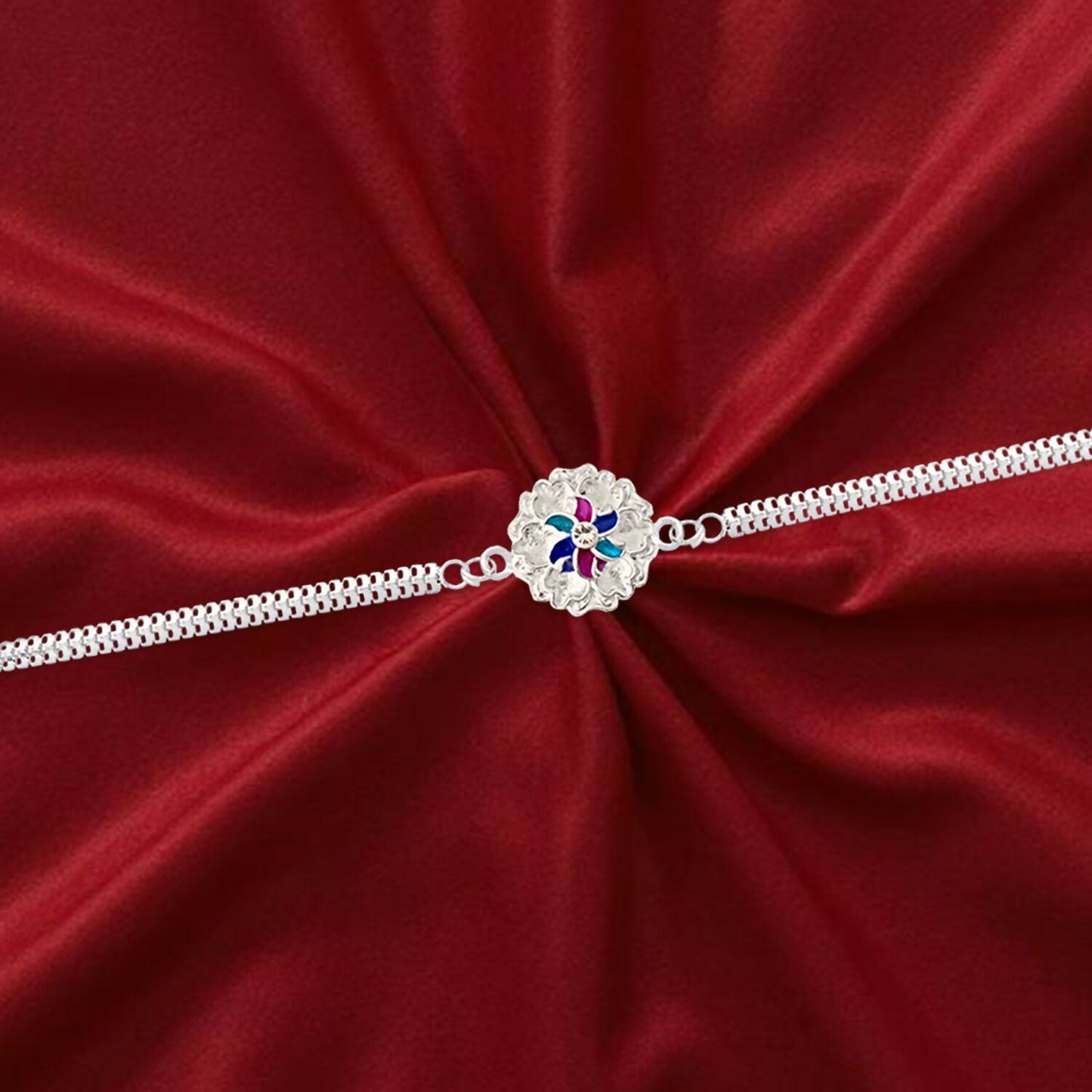 Detailed shot of the silver floral Rakhi's unique dual chain design on a wrist.
