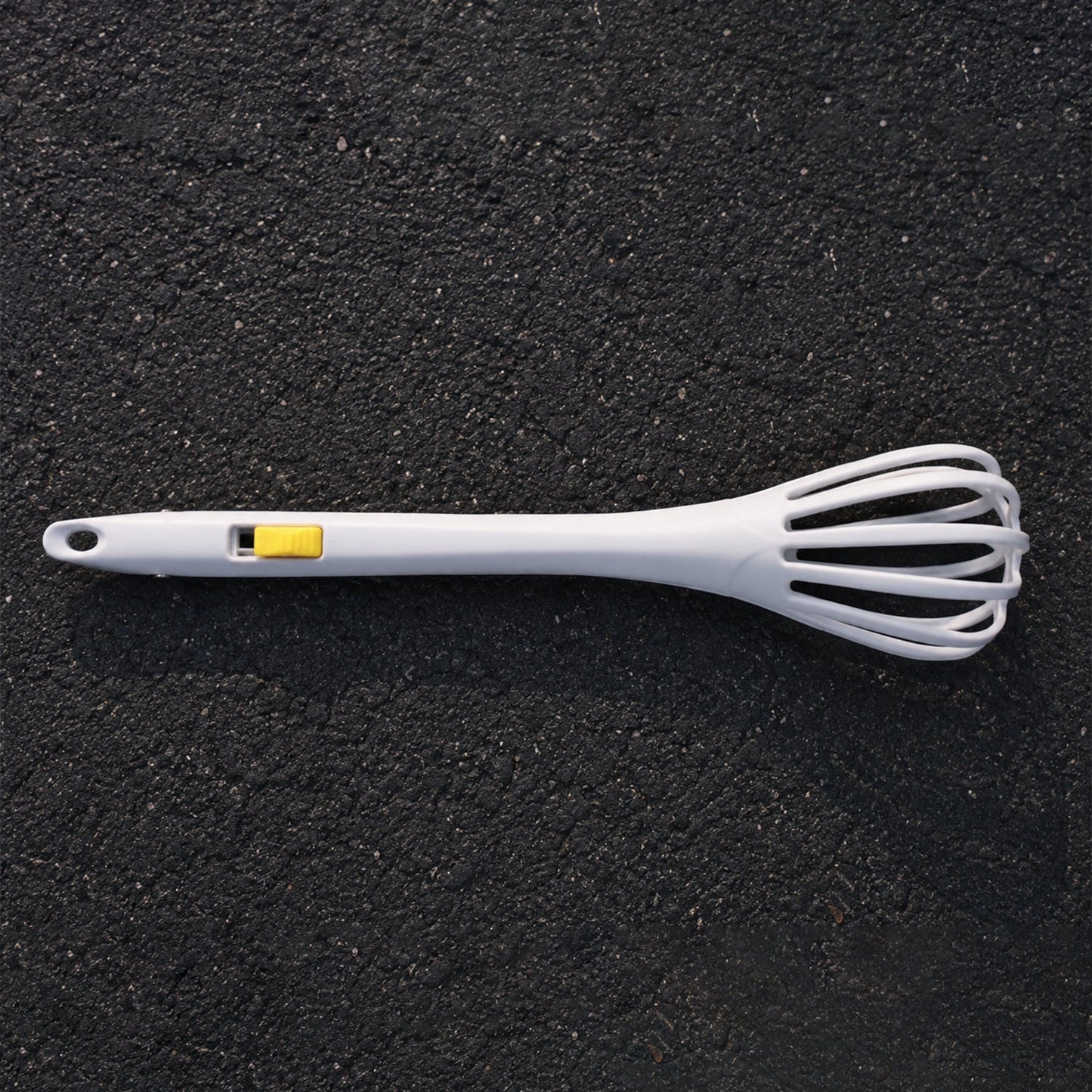White manual egg beater with ergonomic handle for comfortable use.