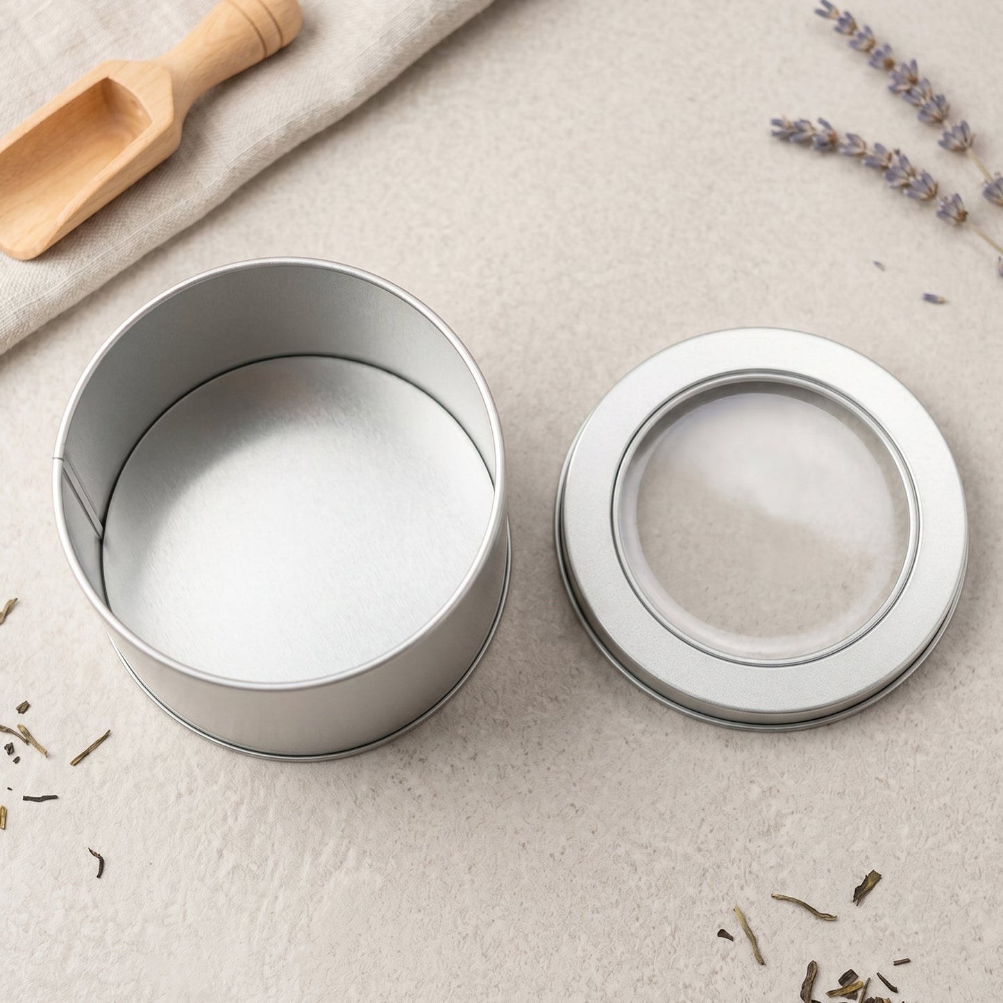 Elegant silver metal tin with clear lid for small item storage and gifting.