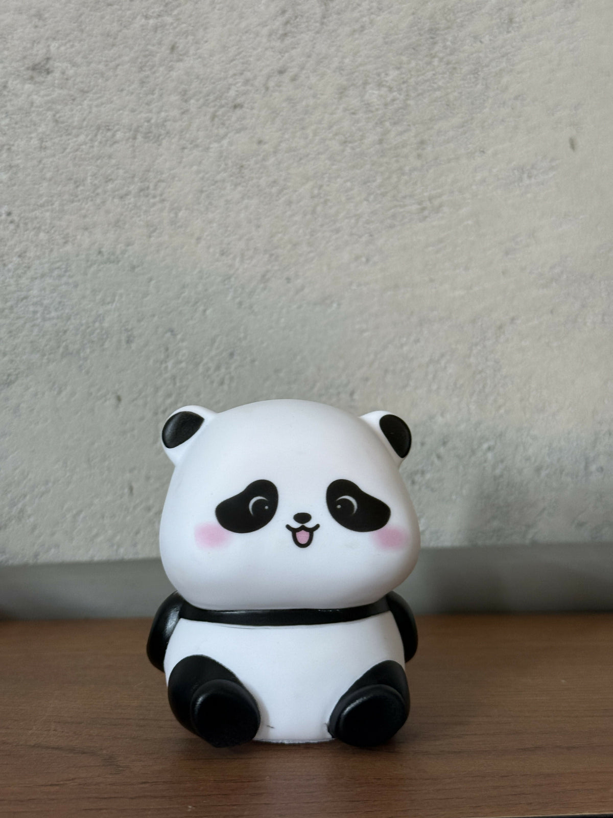 Cute panda LED night lamp placed on wooden bedside table